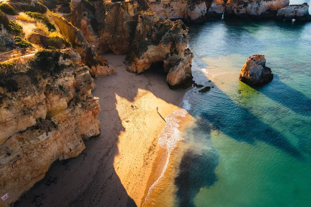 Low winter sun over a quiet Lagos beach and cliffs